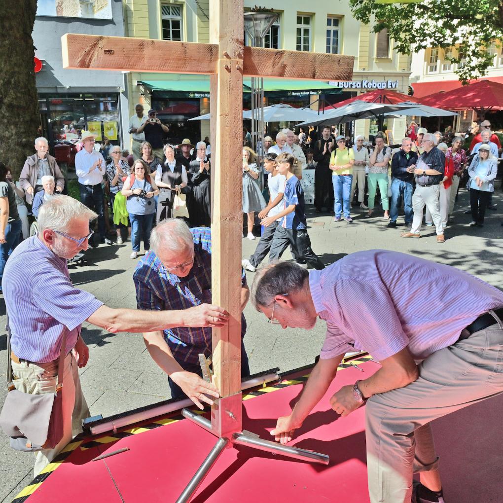 Auf dem Neumarkt werden die vier Kreuzteile, die die Teilnehmer der vier Wallprozessionen getragen haben, zusammengesetzt.