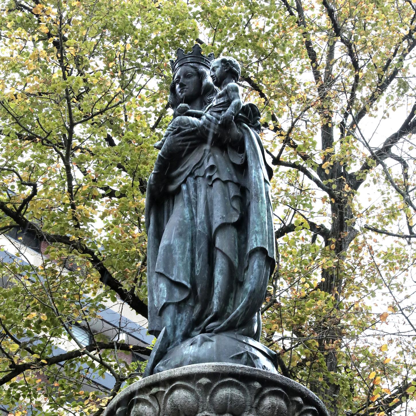 Die bronzene Muttergottes mit dem Christuskind auf dem Arm ist als Friedenskönigin dargestellt.