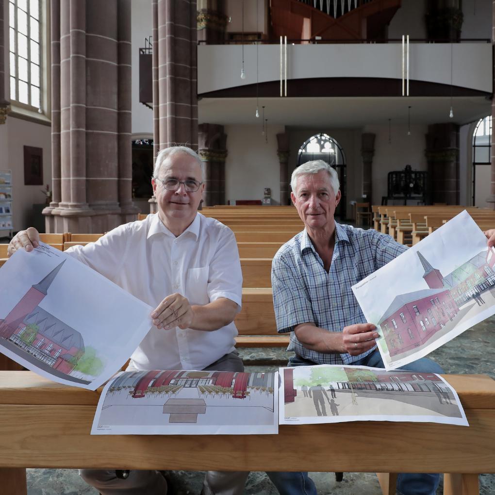 Pfarrer Hans  Russmann (l.) und Ralph Hoepfner vom Kirchenvorstand  St. Augustinus mit den Plänen für das neue Zentrum.