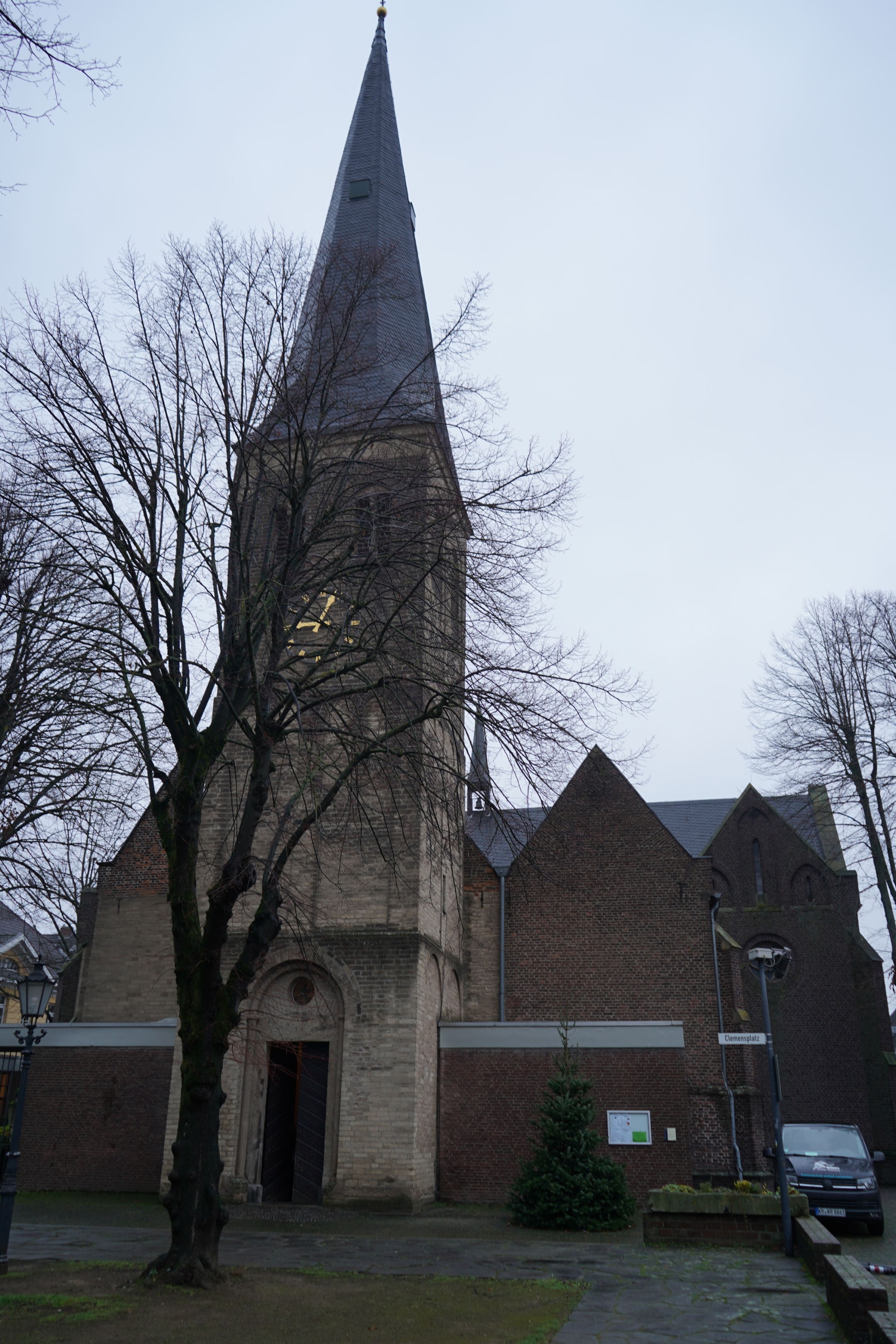 Backsteinkirche mit Turm hinter einem Winterbaum