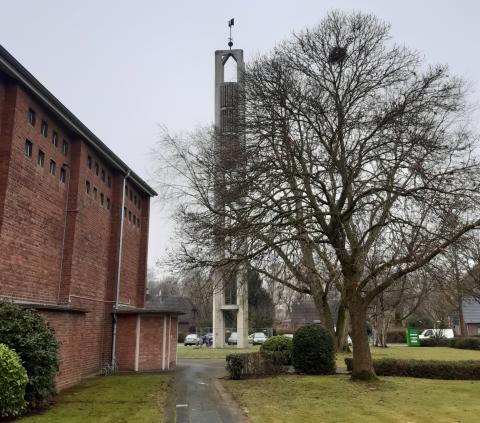 Seitenansicht der Backsteinkirche mit davor stehenden Turm