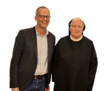 Mann und Ordenschwester stehen zusammen.