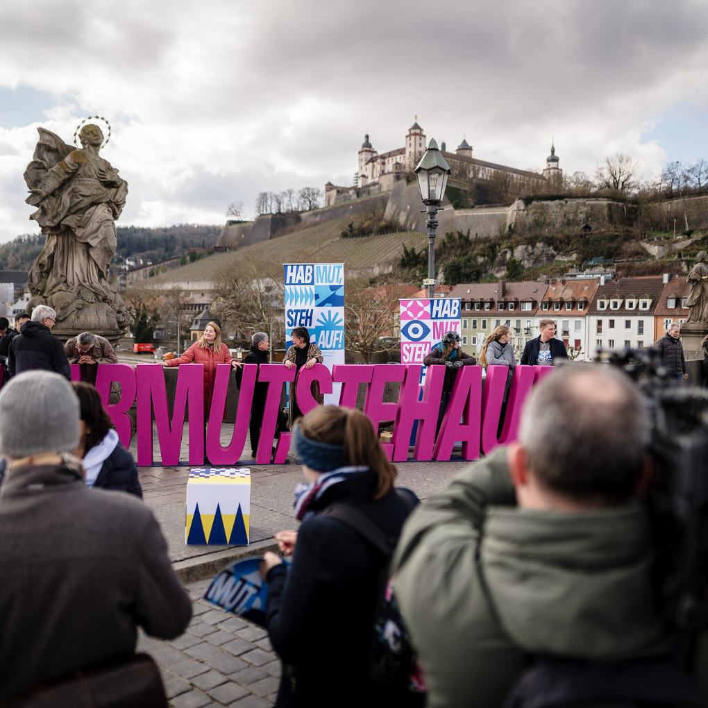 Menschen mit Banner auf Brücke in Würzburg