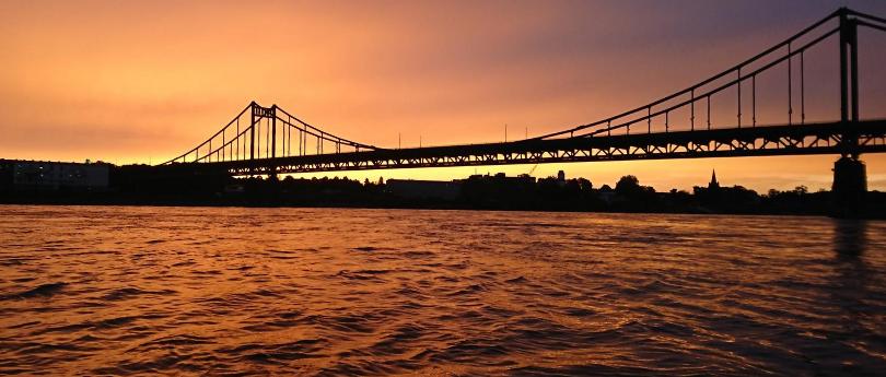 Blick über den Rhein mit der Rheinbrücke bei Uerdingen im untergehenden Abendrot