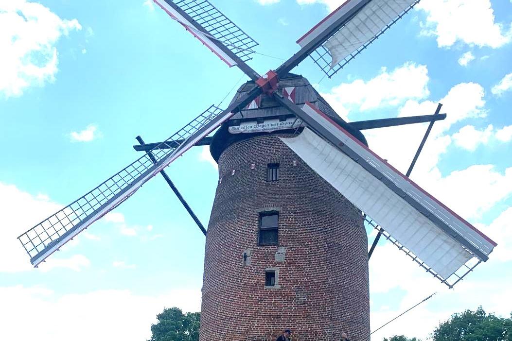 Die Geismühle Krefeld Oppum, im Hintergrund hellblauer Himmel und weiße Wolken.